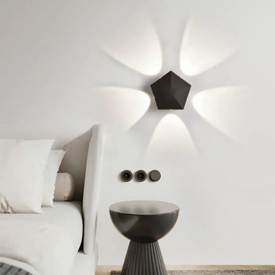 Black Prism Ambient Minimal Wall Lamp casting a warm glow on a textured wall