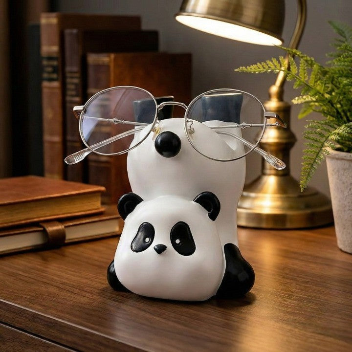 Creative gadget panda holder securing a pair of eyeglasses on a desk