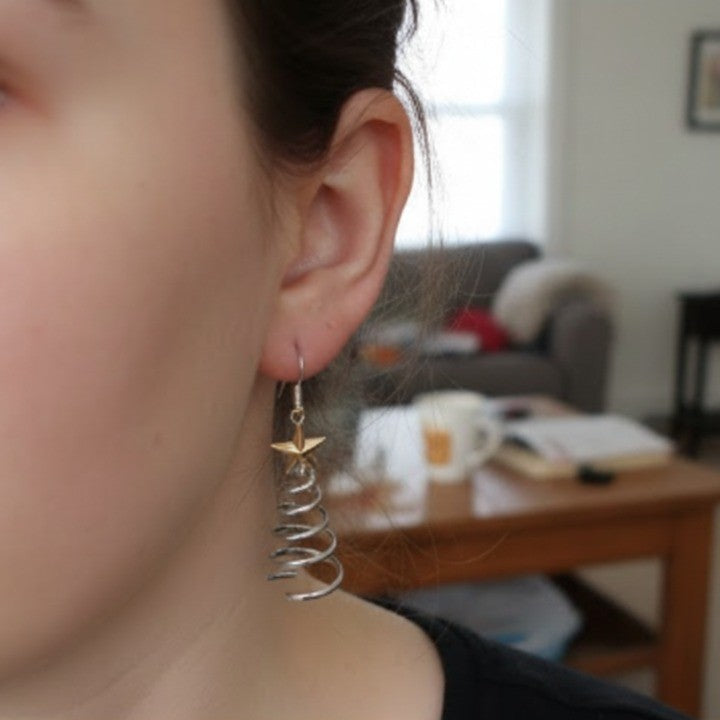 Woman smiling while wearing the Spiral Christmas Tree Dangle Earrings