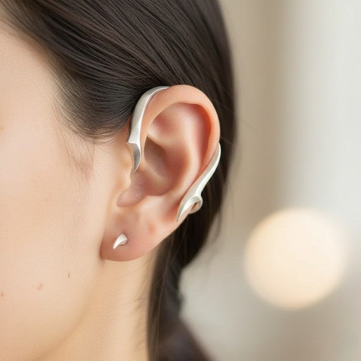 A close-up of the Night Arc Japanese Ear Cuff worn on the left ear, showcasing its sculptural design.