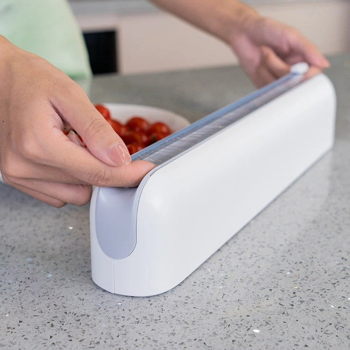 The film cutter dispenser shown with a roll of plastic wrap inside