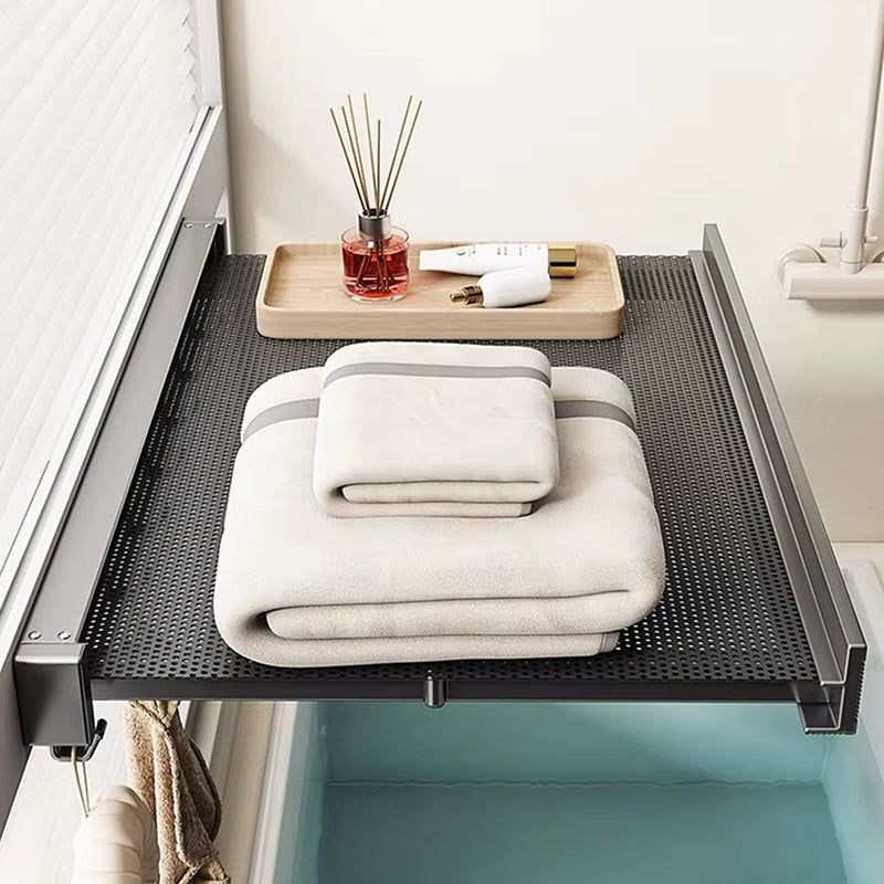 Suction cup towel rack installed on a tiled bathroom wall holding towels and toiletries.