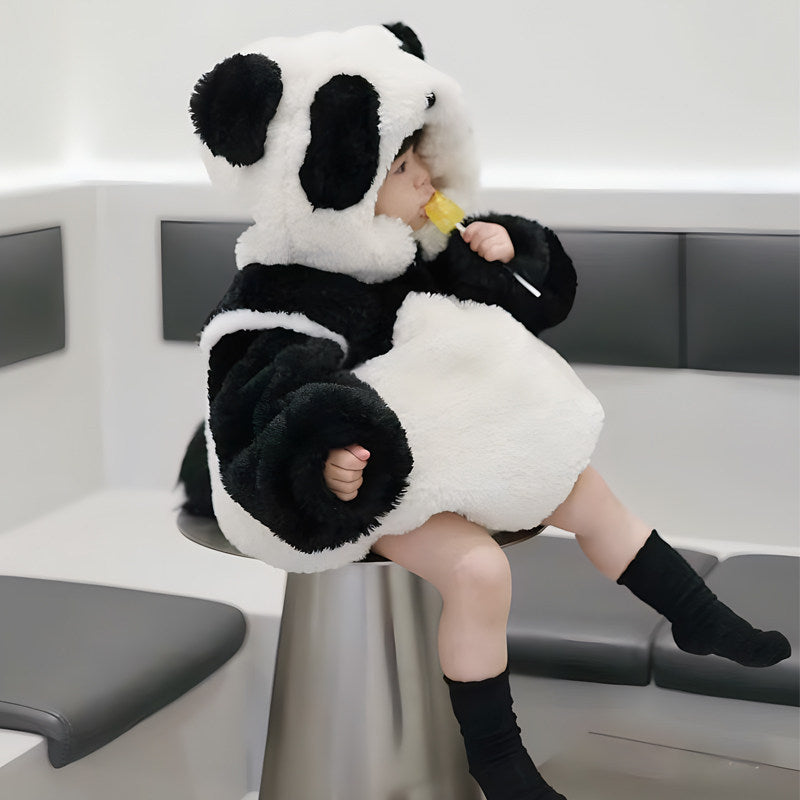 A child playing comfortably in the plush panda onesie