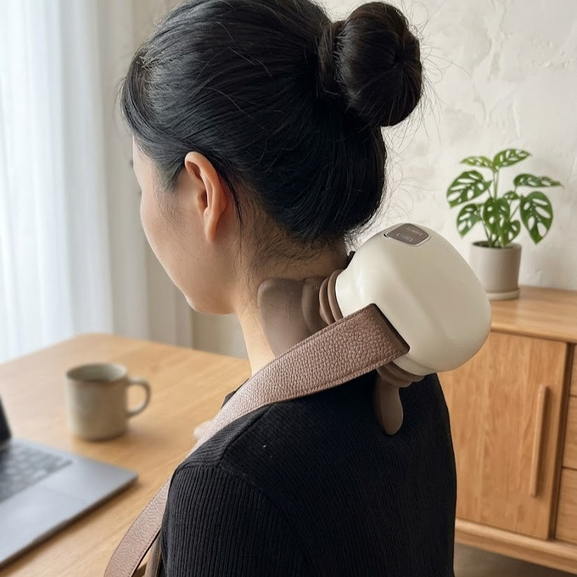 Woman relaxing on a couch using the Deep Touch Neck Shoulder Massager