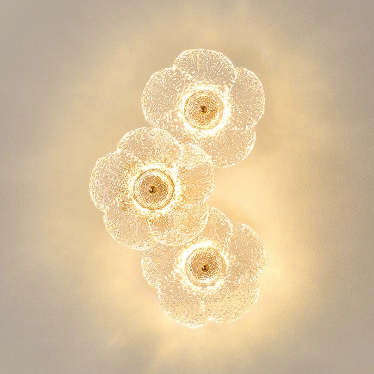 Close-up of the Fiorella sconce lamp's textured glass petals creating a soft glow