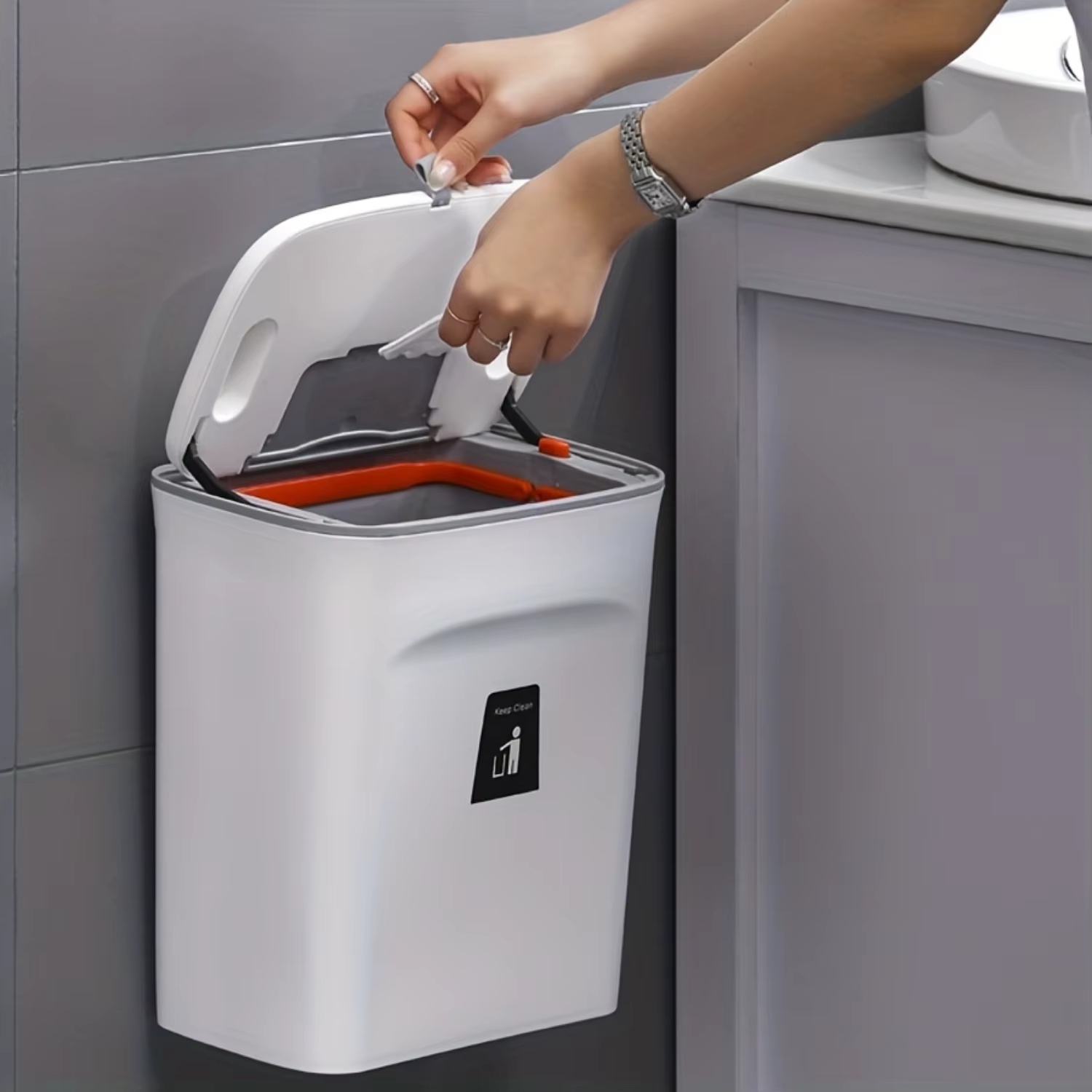 Compact hanging trash can mounted on a kitchen cabinet door