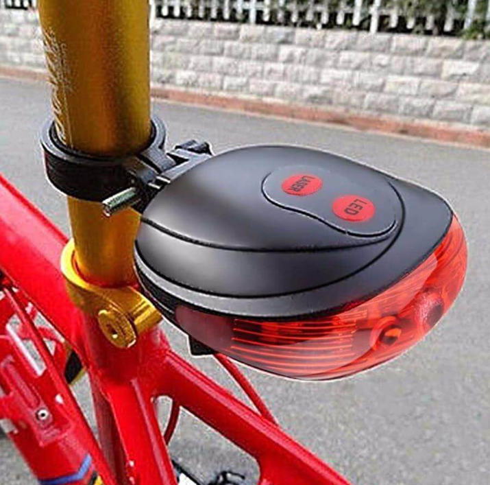 Waterproof LED laser bike tail light projecting two red laser lines on the ground behind a bicycle.