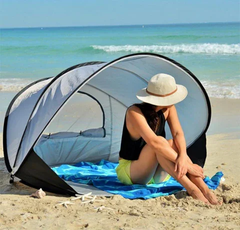 Automatic pop-up beach tent with a simple pull cord mechanism, set on a sandy beach