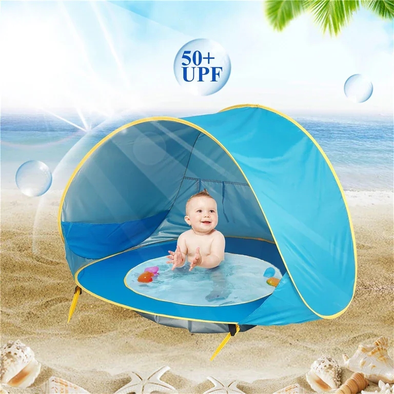 Child playing in a blue beach tent with a small built-in pool, protecting them from sun and sand