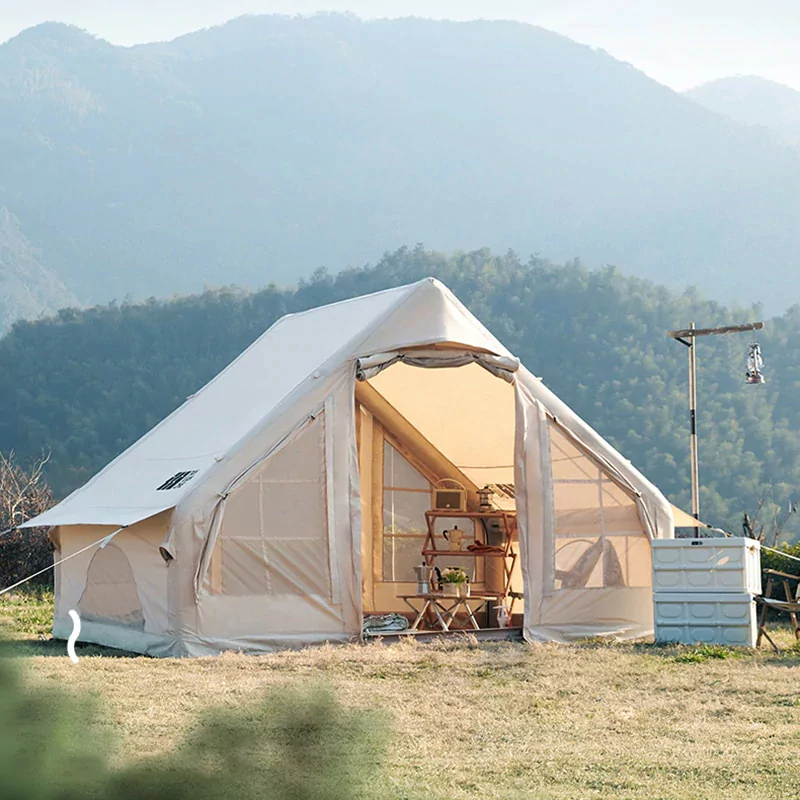 Modern inflatable camping tent with a sleek design, shown inflated and ready for use in a natural setting.