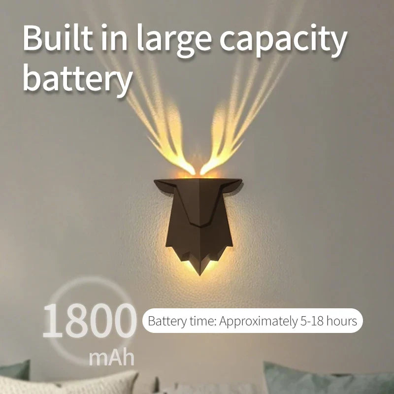 The deer wall lamp casting a warm, ambient glow in a dark room