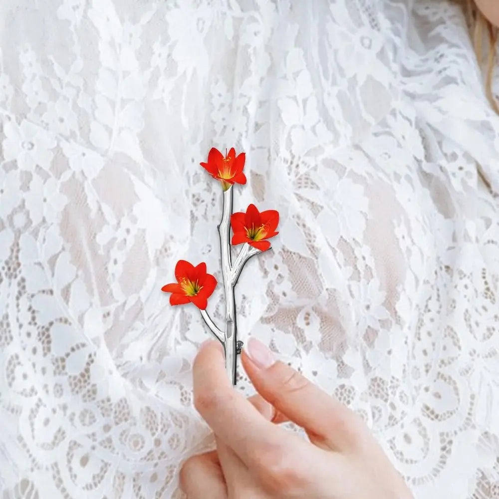 A person wearing the Wear A Flower Branch Pin Brooch with a small white flower on a green sweater