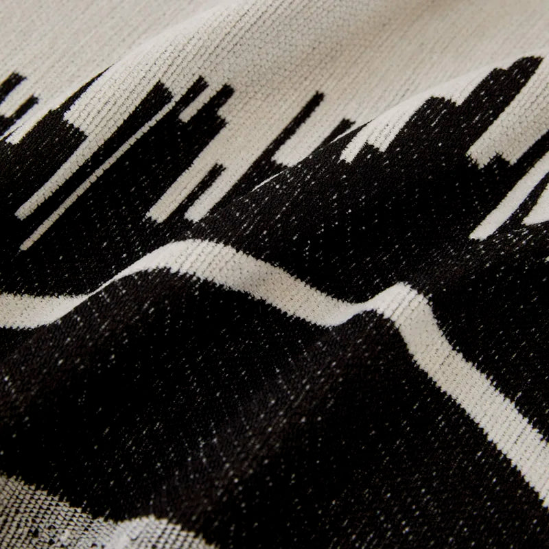 Geometric throw used as a decorative accent on a bed
