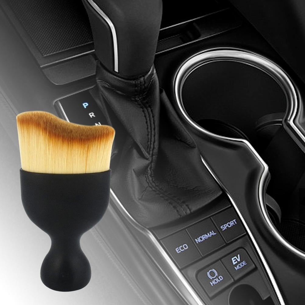Using the dashboard cleaning brush on a car's air vent