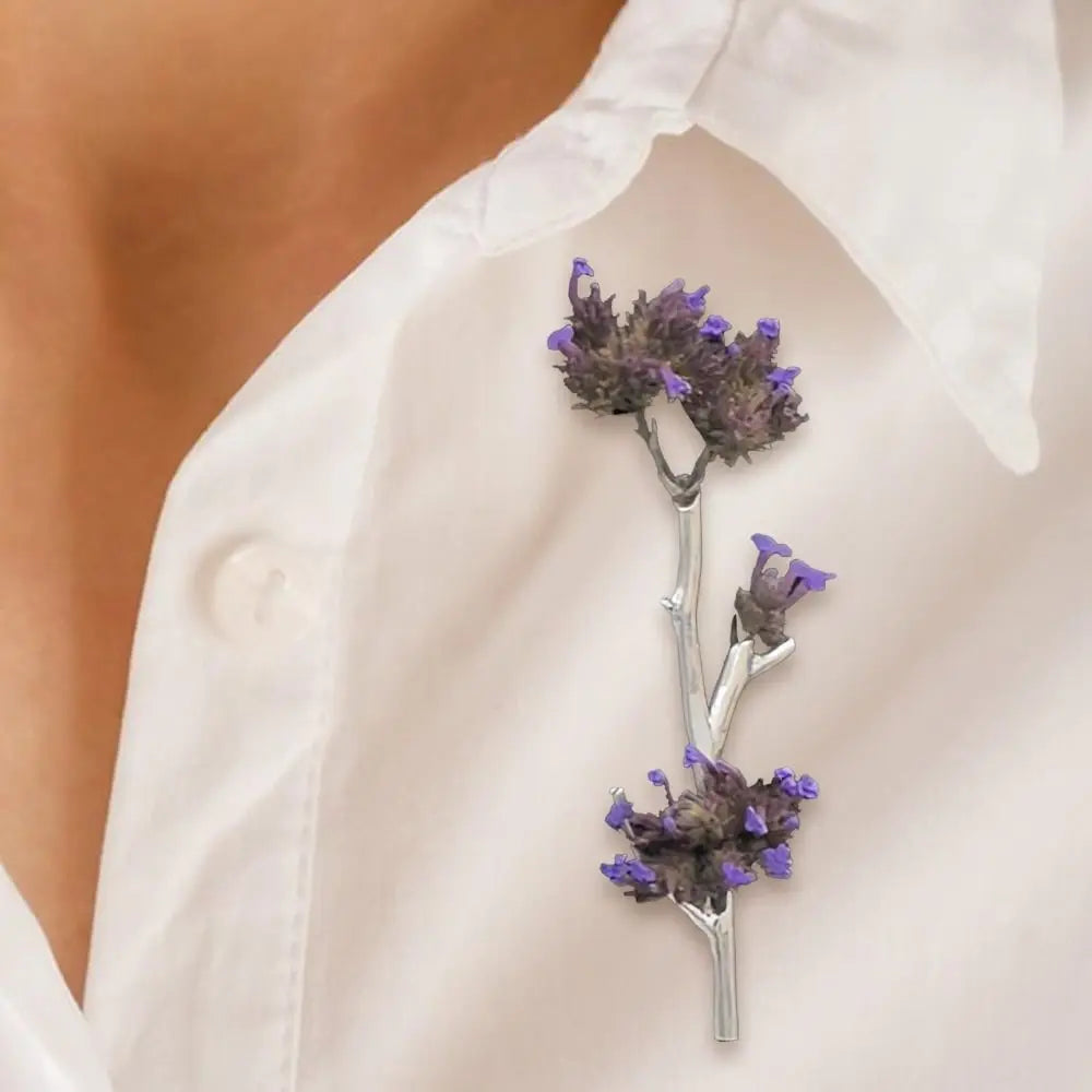 A person attaching the flower pin brooch to their white shirt