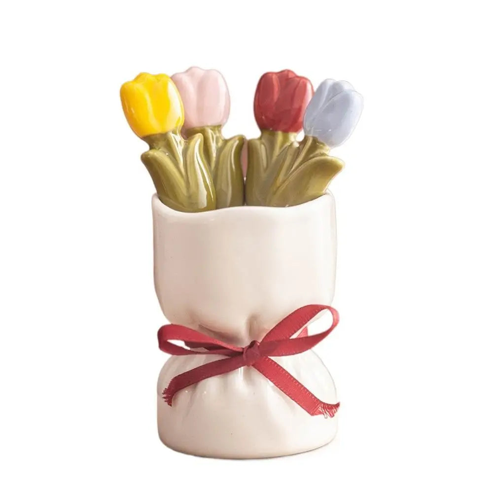 A person using the tulip dessert fork to eat a piece of cake