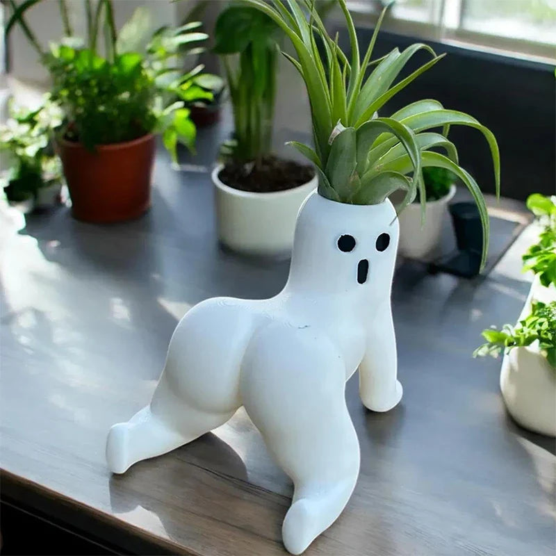 A quirky ghost shaped mini vase holding a small plant