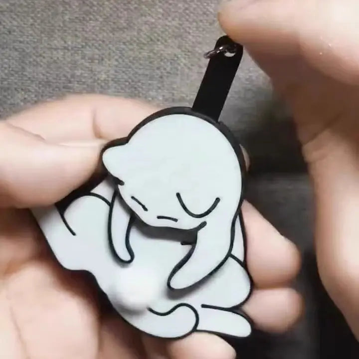 A lifestyle image showing the cat keychain being used as a decorative backpack charm