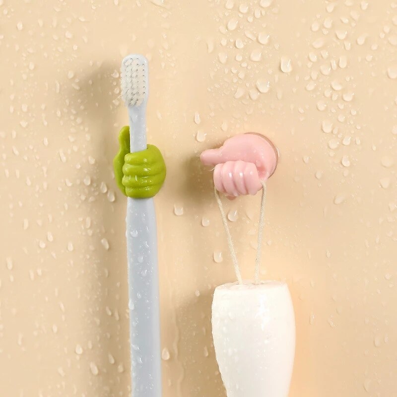 Thumbs-up sticky wall hook holding a charging cable