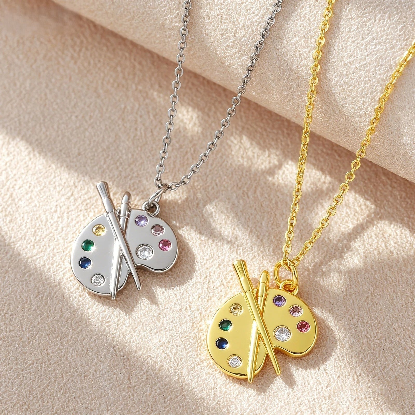 Gold and silver versions of the artist palette necklace side by side