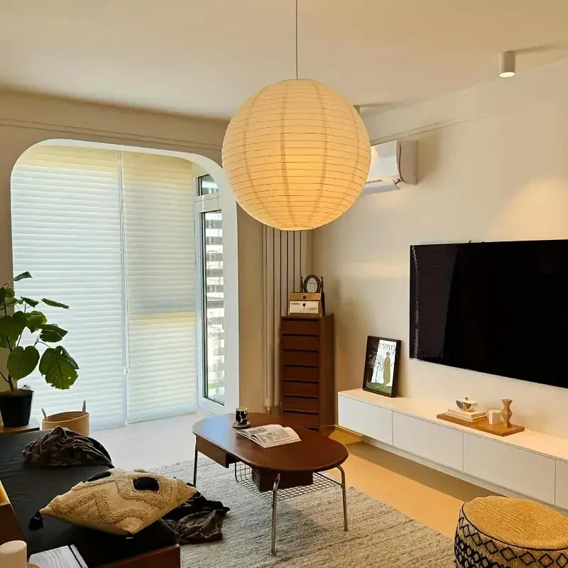 A glowing Japanese paper lantern lamp hanging in a minimalist living room