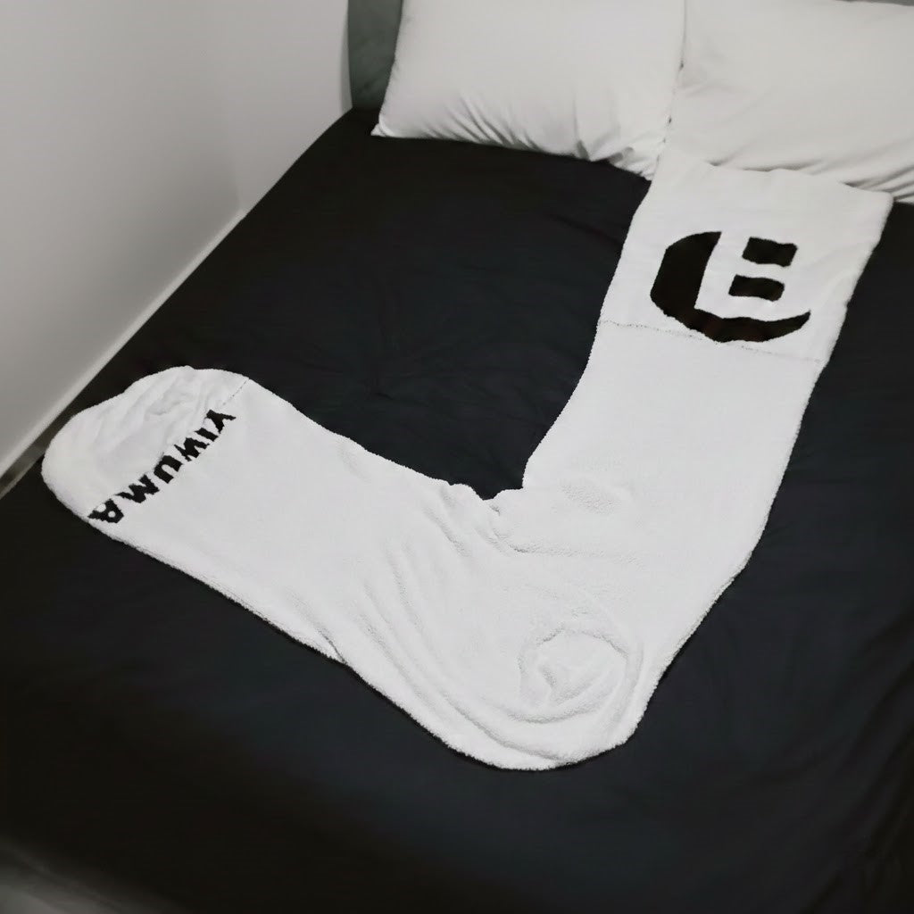 Someone relaxing in the giant sock blanket bag, showcasing its full-body coverage